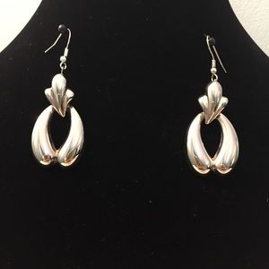 Silver tone door knocker style earrings.